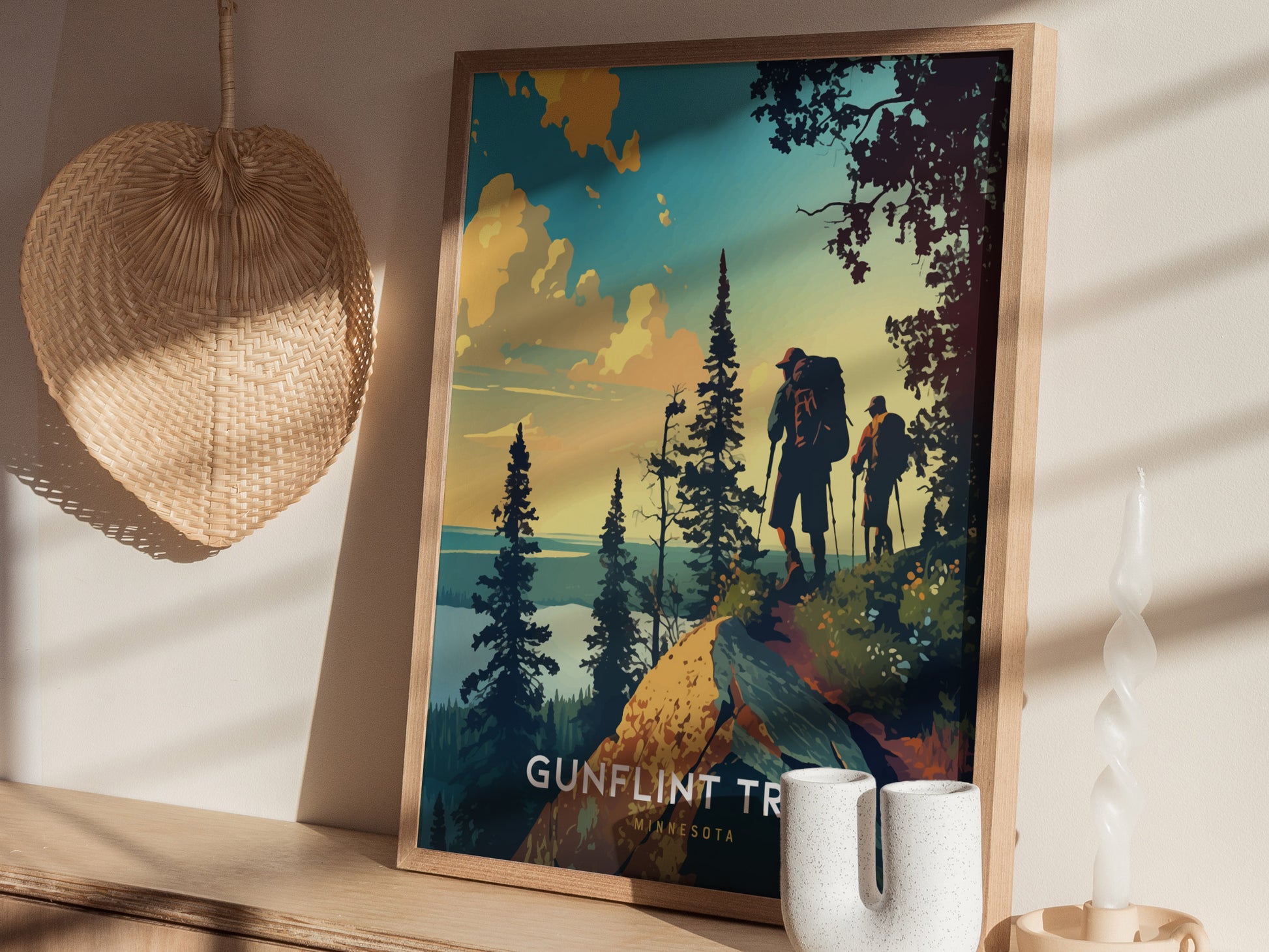 A framed poster depicting two hikers on a scenic trail surrounded by pine trees and a colorful sky, set against a wooden shelf with decorative items.