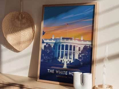 A framed poster of the White House with a vibrant sunset background is displayed on a shelf, accompanied by a woven wall decoration and a uniquely shaped white candle.