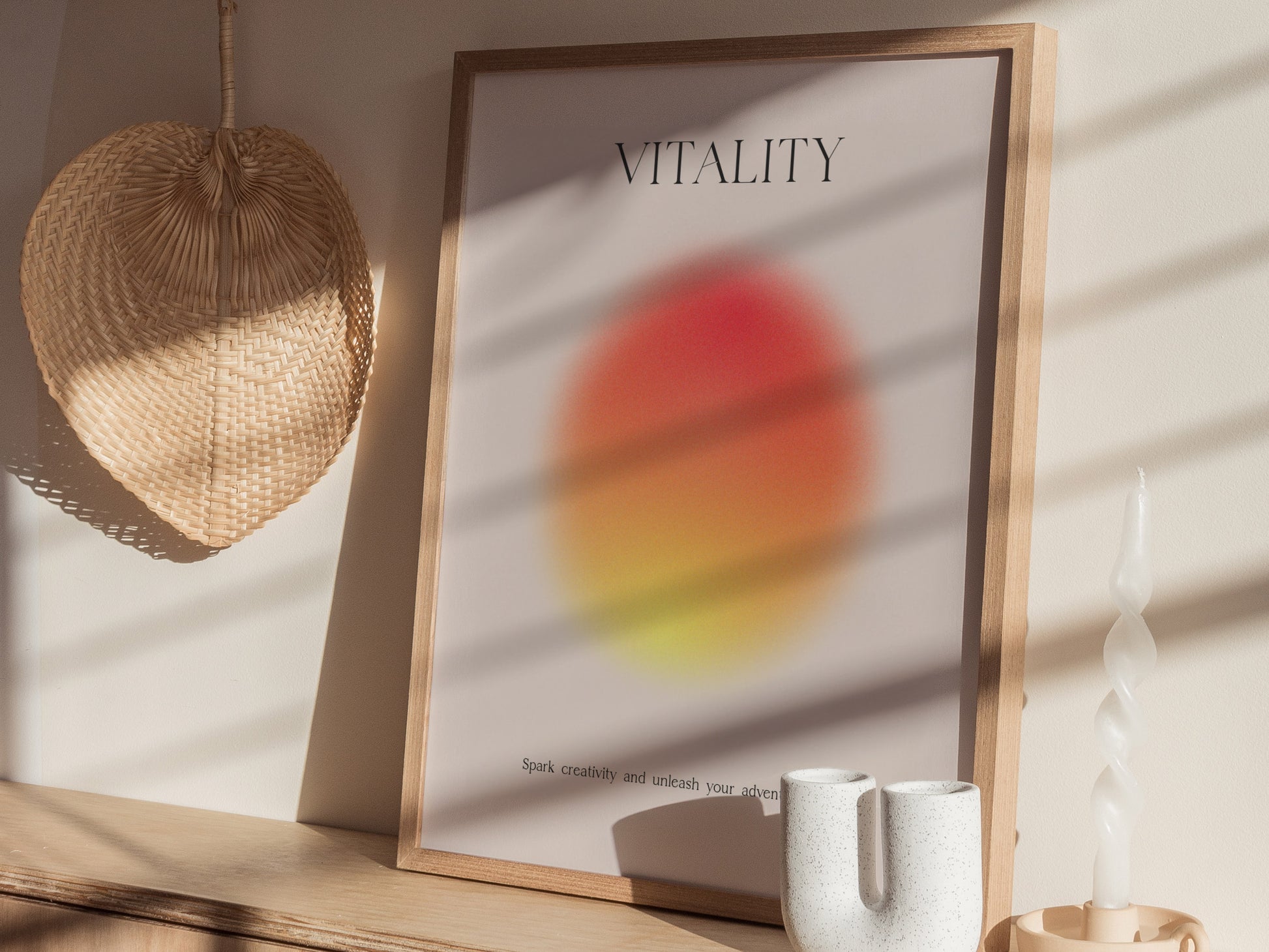 Framed poster with 'VITALITY' text on a wall with a light fixture and vase.