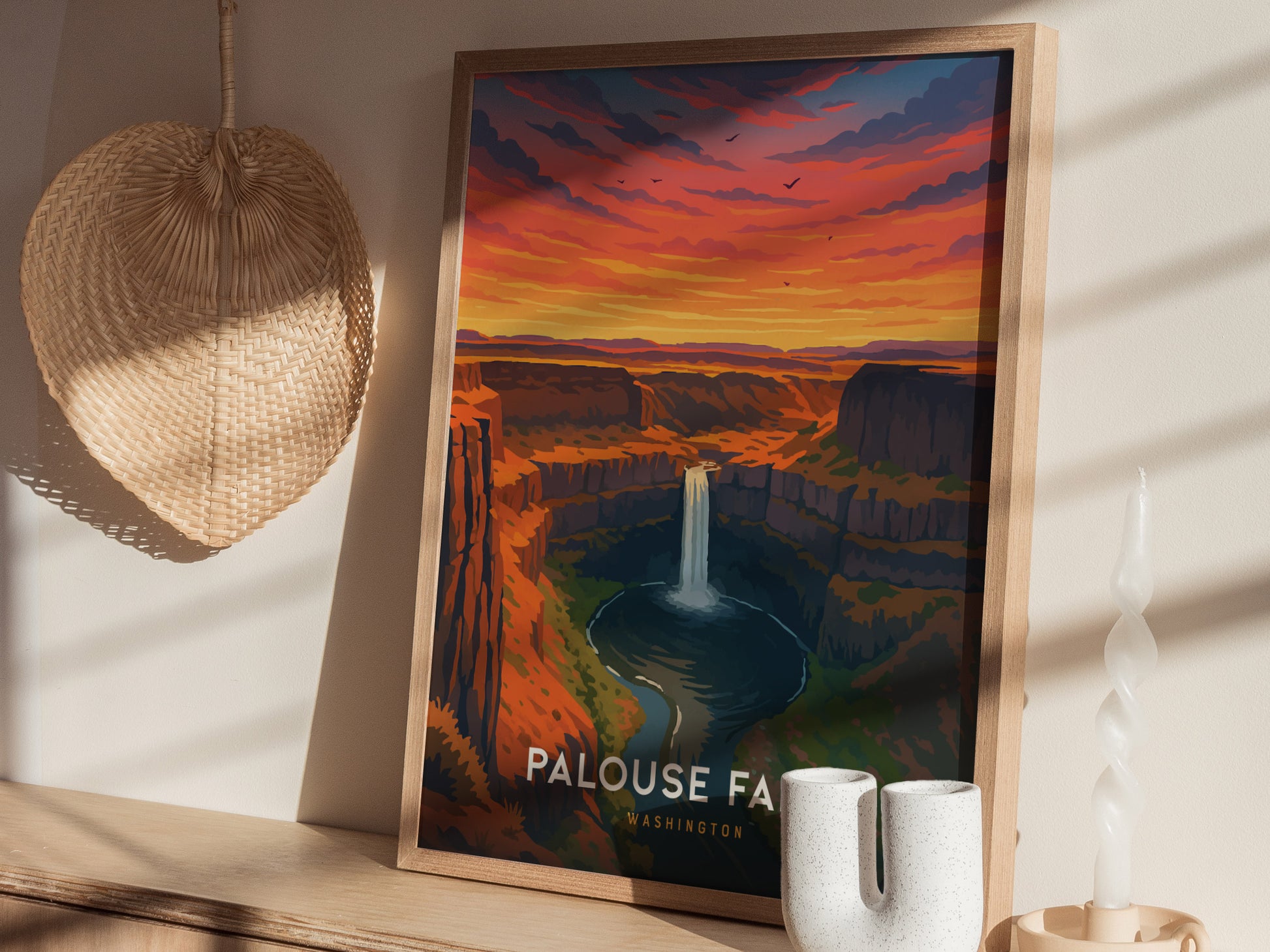 A framed travel poster of Palouse Falls in Washington showcases a stunning sunset with vibrant orange and purple hues above rocky cliffs.