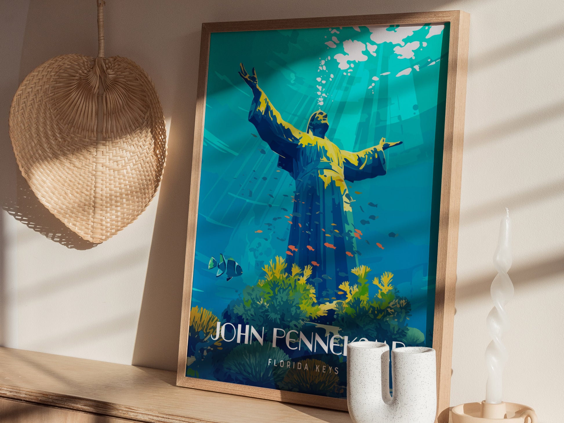 A framed poster of an underwater scene with a statue, corals, and fish is displayed on a wooden shelf, accompanied by a woven basket and a sculpted candle.