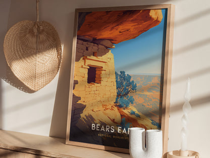 A framed Bears Ears National Monument poster rests on a wooden shelf with a straw wall decoration and a white twisted candle nearby. Sunlight casts soft shadows across the scene.