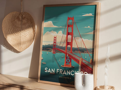 A framed poster of the Golden Gate Bridge in San Francisco rests on a wooden shelf, with a woven basket and a twisted candle nearby.