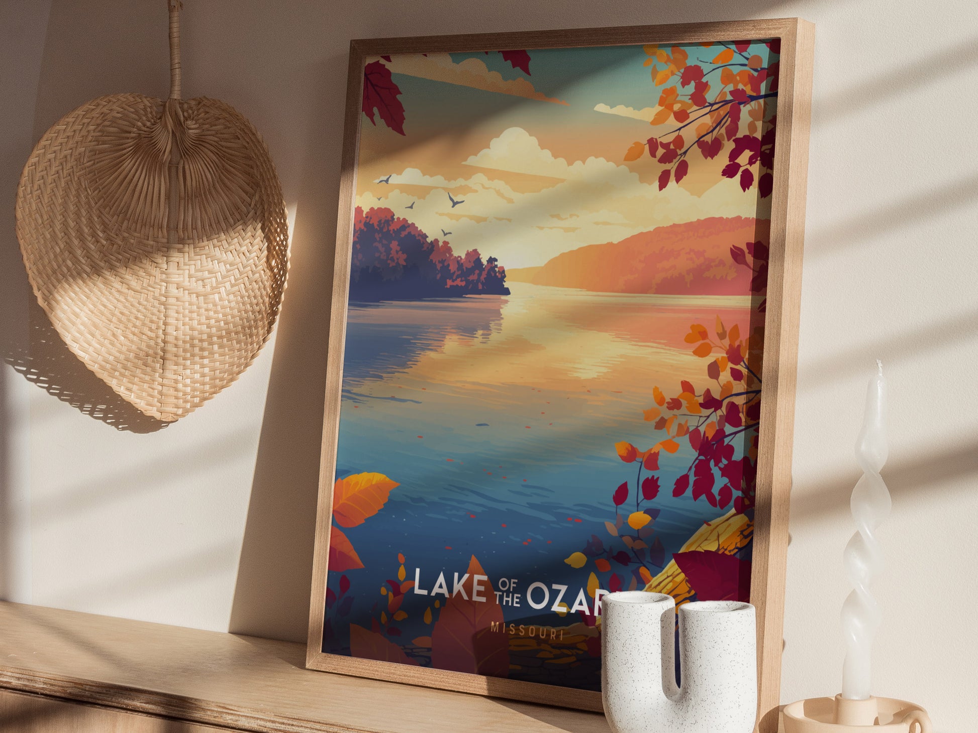 A beautifully framed poster titled Lake of the Ozark depicts a serene lake scene at sunset, with vibrant autumn leaves in shades of red and orange.