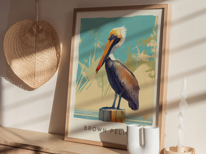 A framed poster of a brown pelican perched on a post, displayed on a shelf with a woven wall decoration and a twisted white candle nearby.