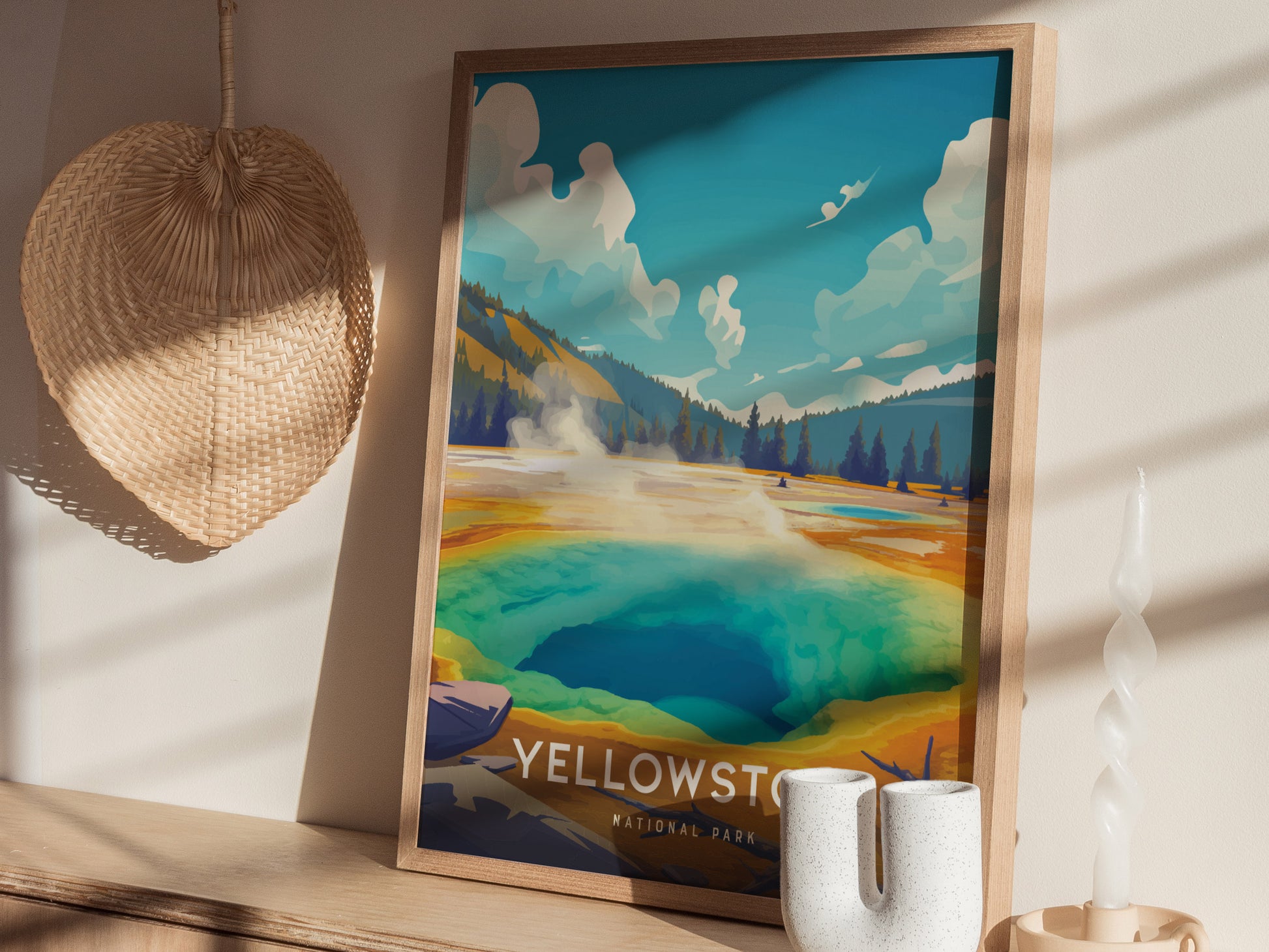 A framed Yellowstone National Park poster featuring Morning Glory Pool in vibrant colors is displayed on a wooden shelf, alongside a woven wall decoration and a twisted candle.