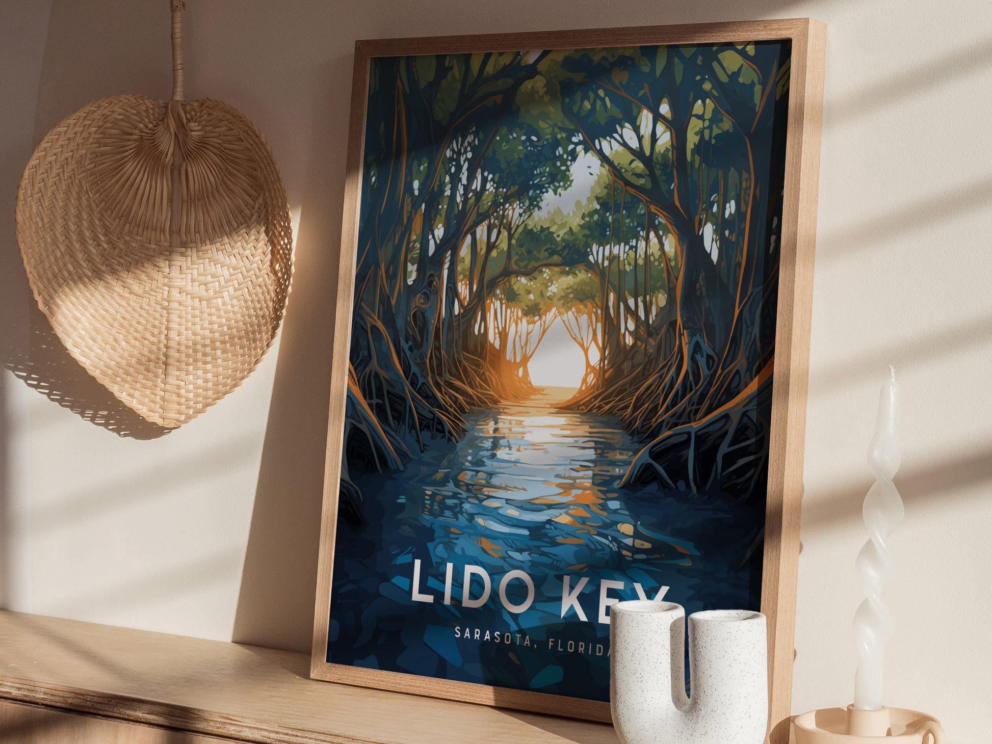 A framed poster depicting a serene mangrove scene with water reflecting sunlight is placed on a shelf beside a woven wall decoration and decorative candles.