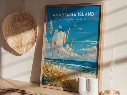 A framed poster of Anastasia Island, St. Augustine, Florida, depicting sea oats, ocean waves, and seabirds, is displayed on a wooden shelf with a woven basket and a twisted candle.