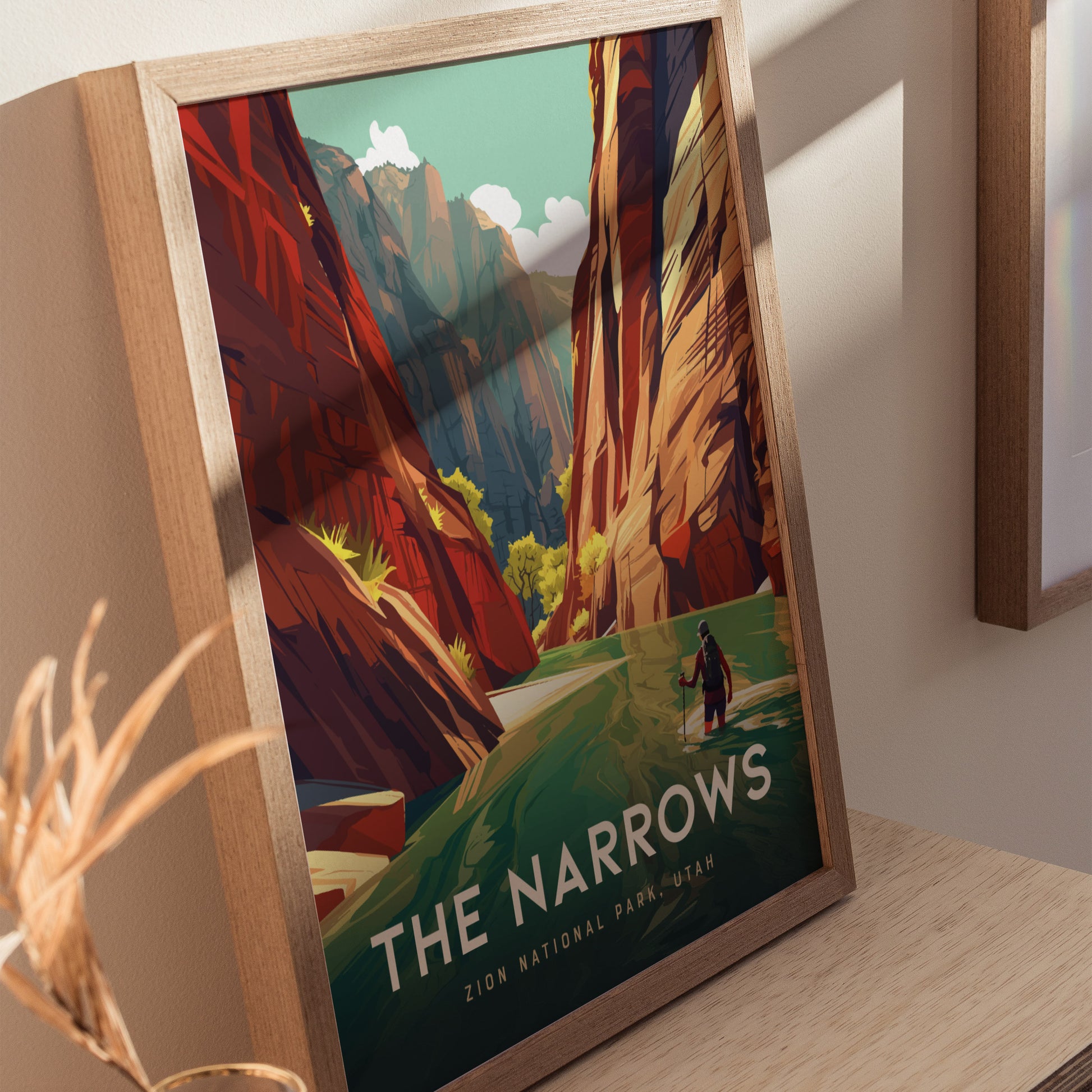Framed poster depicting The Narrows in Zion National Park, featuring towering red canyon walls, a hiker in the river, and lush greenery under a clear sky.