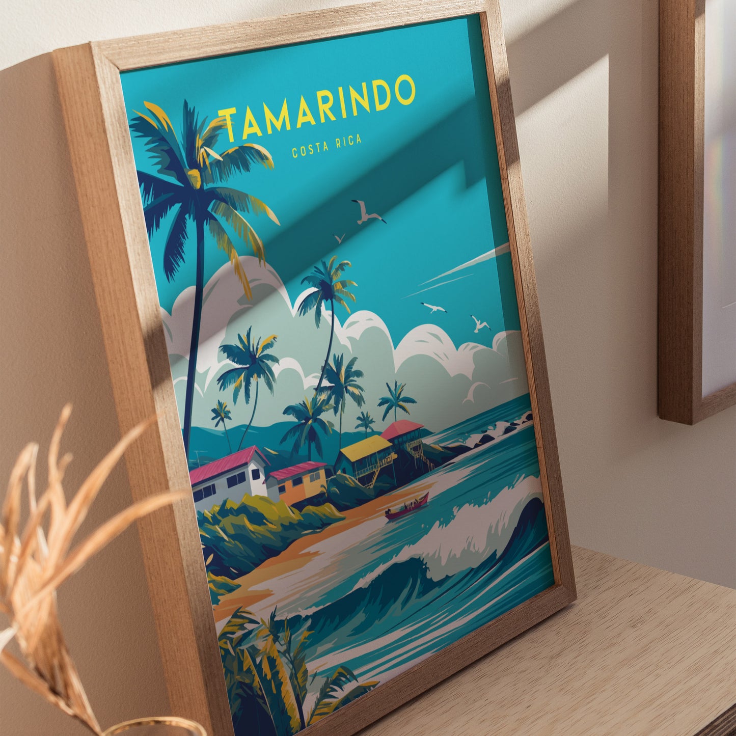 Framed poster featuring vibrant artwork of Tamarindo, Costa Rica, with palm trees, colorful houses, and ocean waves. Seagulls fly in a bright blue sky above the beach scene.