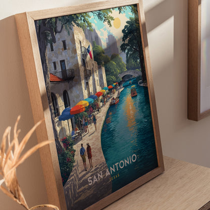 Framed artwork featuring San Antonios vibrant riverwalk with colorful umbrellas, people strolling along the water, and a boat under a sunny sky. The text reads San Antonio, Texas.