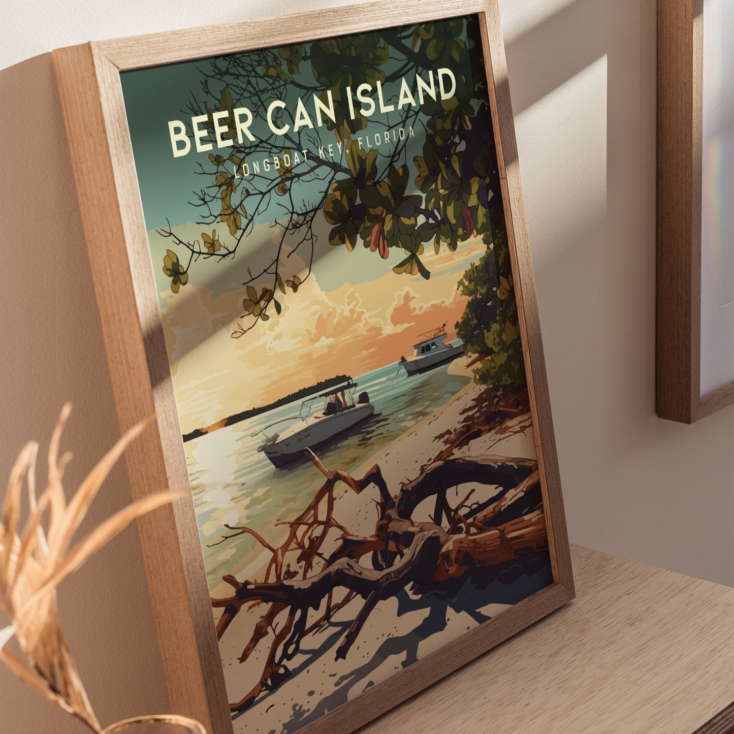 Framed artwork depicting a serene coastal scene at Beer Can Island, Longboat Key, featuring boats anchored in turquoise waters, driftwood on the beach, and lush greenery under a sunset sky. The poster leans against a light-colored wall.