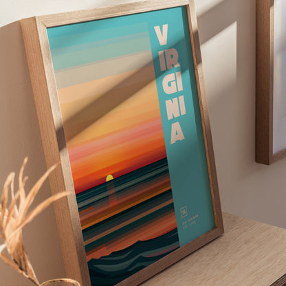 Framed Virginia poster with a minimalist design features a colorful sunset over the ocean, with bold text reading VIRGINIA on a teal background.