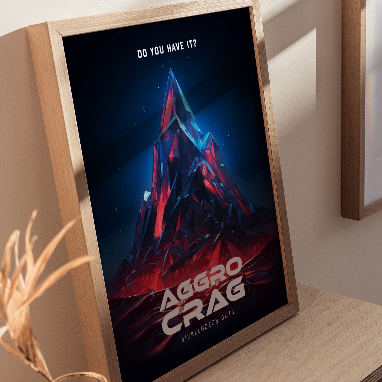 Framed Aggro Crag poster featuring a vibrant, geometric mountain with red and blue hues, set against a dark background. The text Do You Have It? appears at the top.