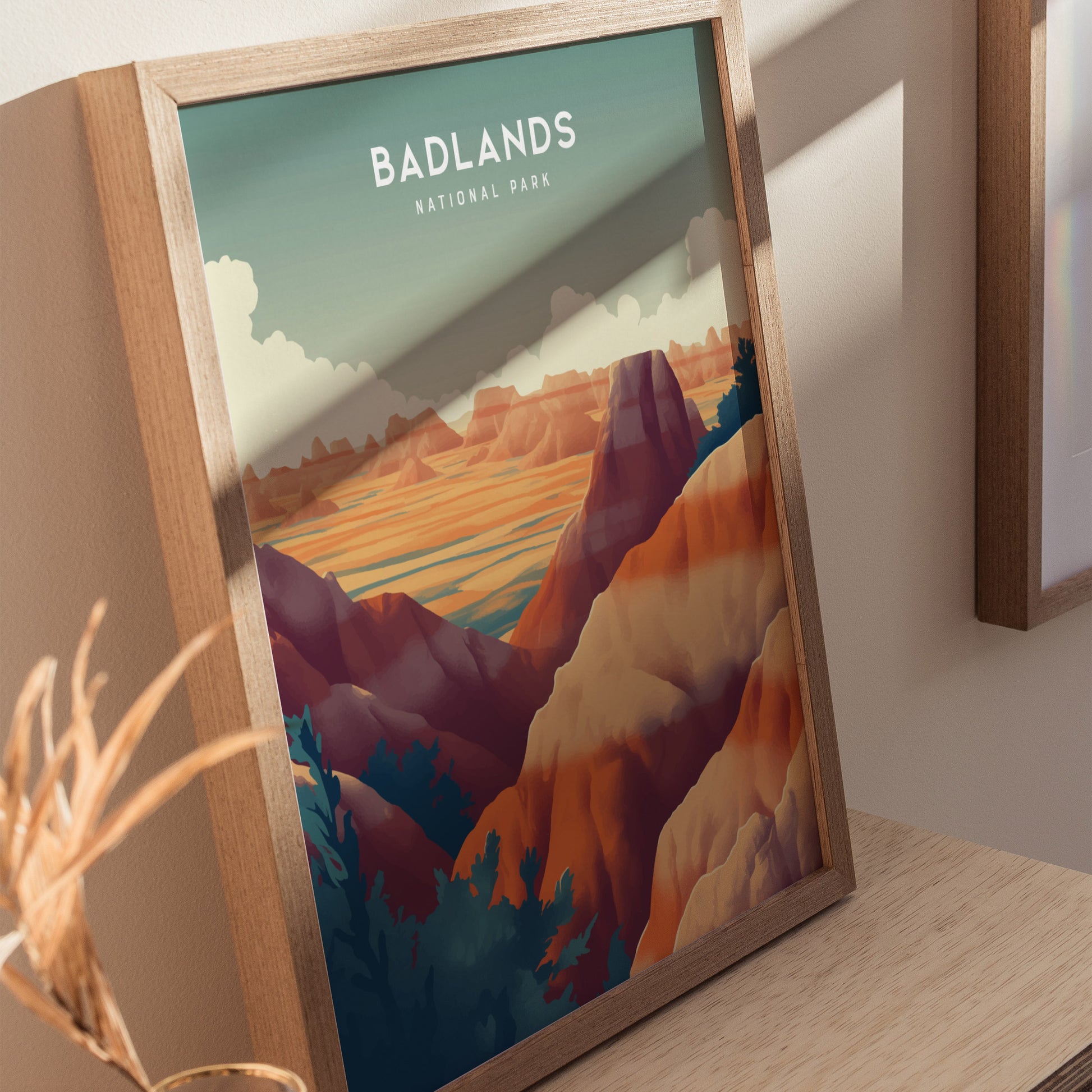 Framed poster of Badlands National Park showcasing vibrant, colorful rock formations under a cloudy sky, resting on a wooden surface with natural lighting.