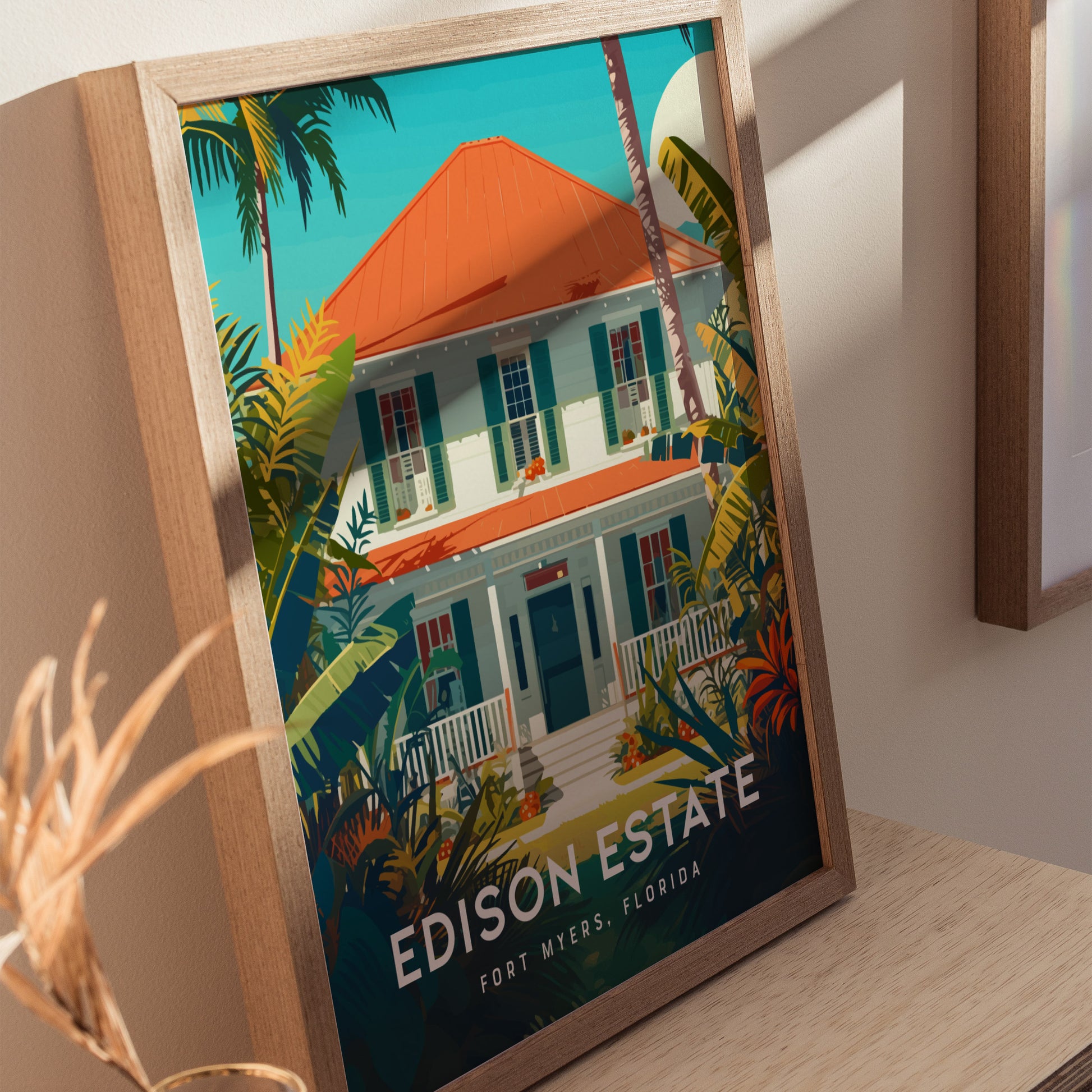 Framed poster depicting the Thomas Edison Estate in Fort Myers, Florida, featuring a white house with a red roof, surrounded by lush tropical plants and palm trees.