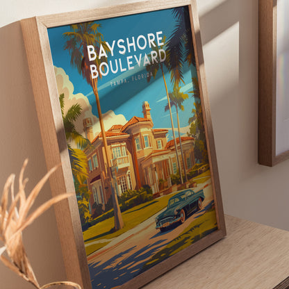 Framed artwork depicting a scenic view of Bayshore Boulevard in Tampa, Florida, featuring a classic car, palm trees, and an elegant mansion under a clear blue sky.