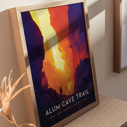 A framed poster depicting a hiker silhouetted against a vibrant, abstract landscape of orange and yellow cliffs, titled Alum Cave Trail, Great Smoky Mountains National Park.
