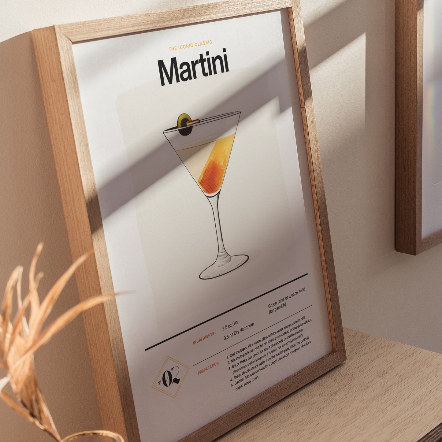 Framed poster featuring a martini glass illustration, with a classic dry martini recipe below. The print is displayed on a wooden surface, with soft natural lighting.