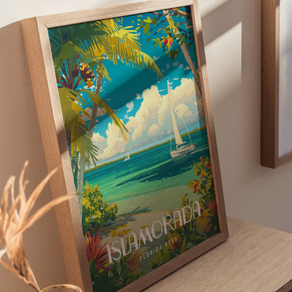 A colorful poster of Islamorada, Florida Keys, features palm trees, turquoise waters, a sailboat, and vibrant foliage, all framed in wood and leaning against a light-colored wall.