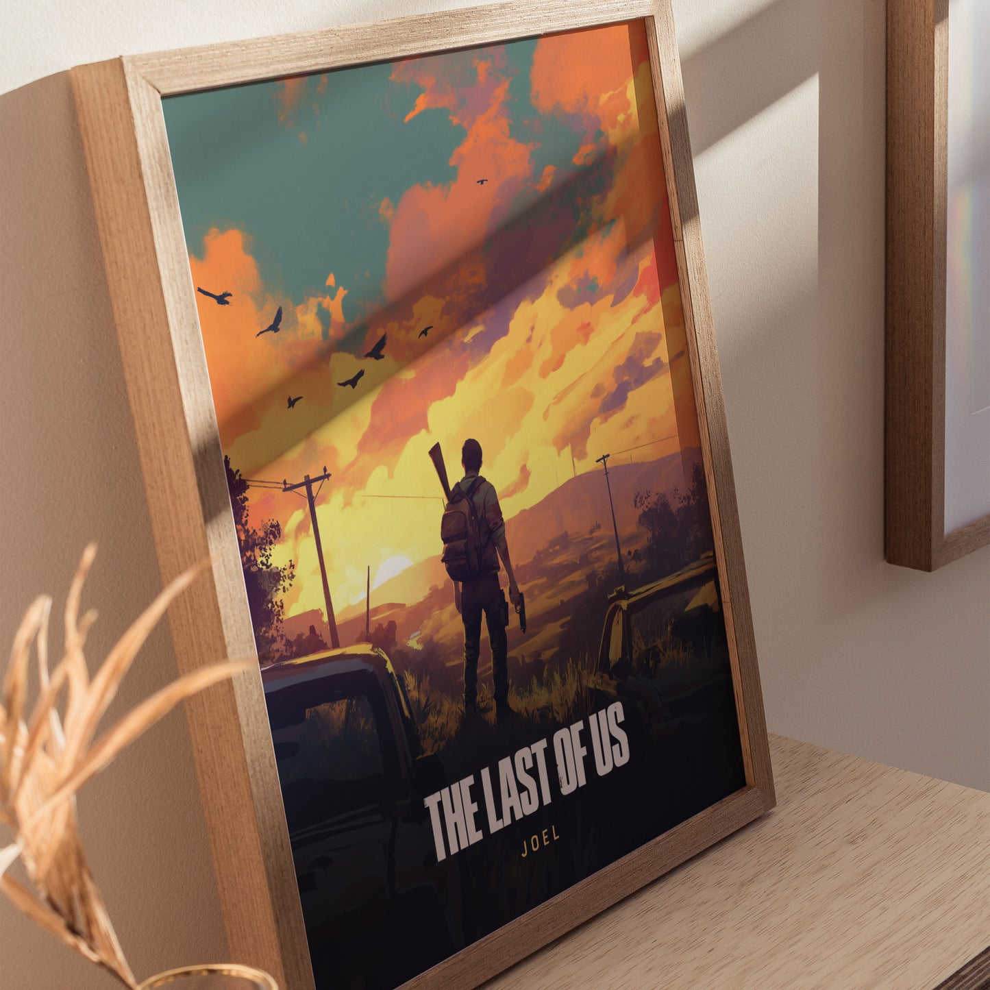 Framed poster of The Last of Us featuring a silhouette of a person with a backpack and rifle, set against a vivid sunset with birds in the sky.