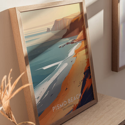 Framed artwork depicting a stylized Pismo Beach with vibrant orange cliffs, turquoise waters, and gentle waves under a sunset sky. The poster rests on a wooden surface.