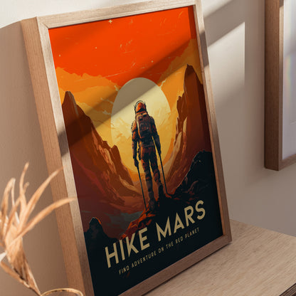 A framed poster depicts an astronaut standing on Martian terrain with towering cliffs and a large sun. The text reads Hike Mars: Find Adventure on the Red Planet.