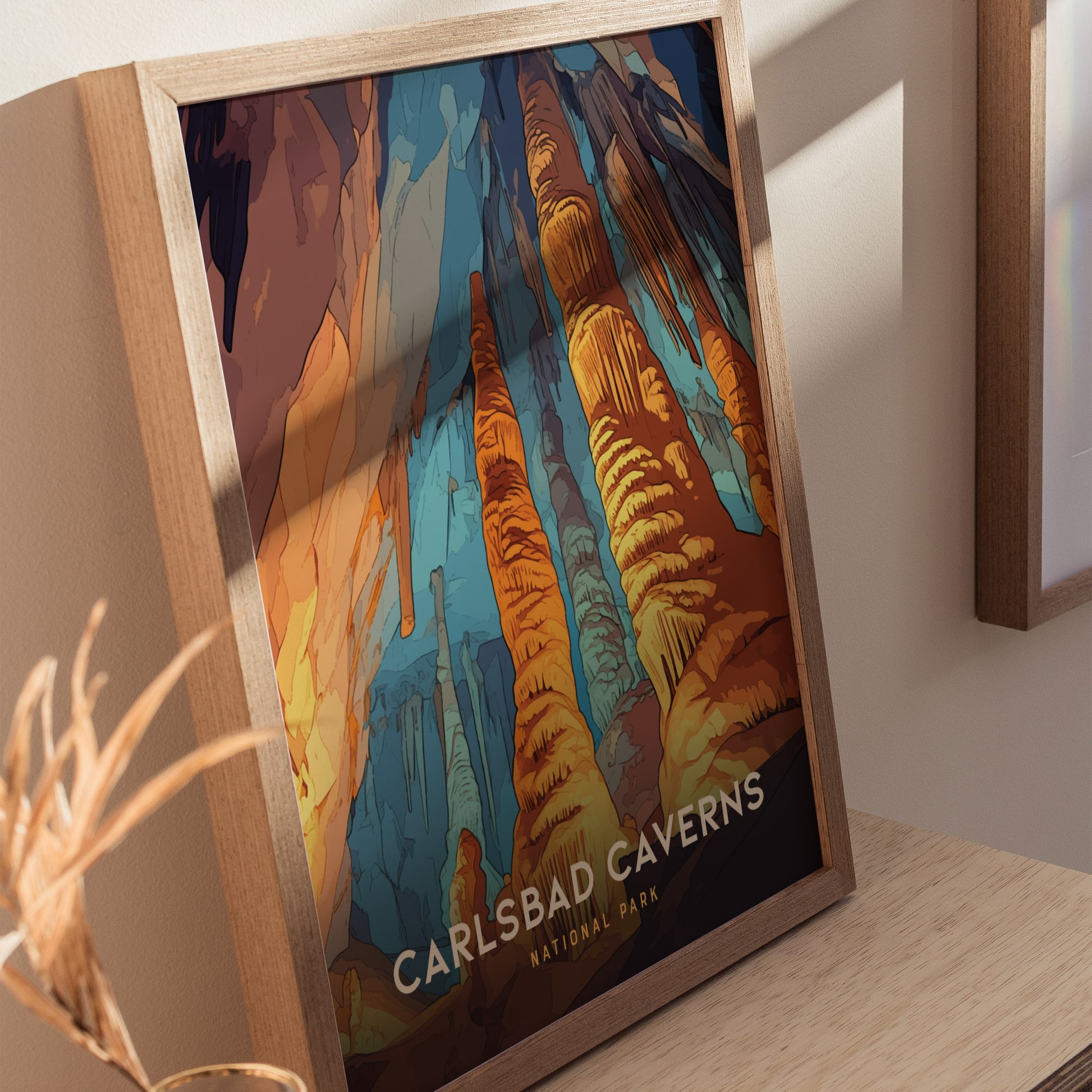 Framed Carlsbad Caverns National Park poster showcasing vibrant rock formations in blue, orange, and yellow hues, placed on a wooden surface with natural lighting.
