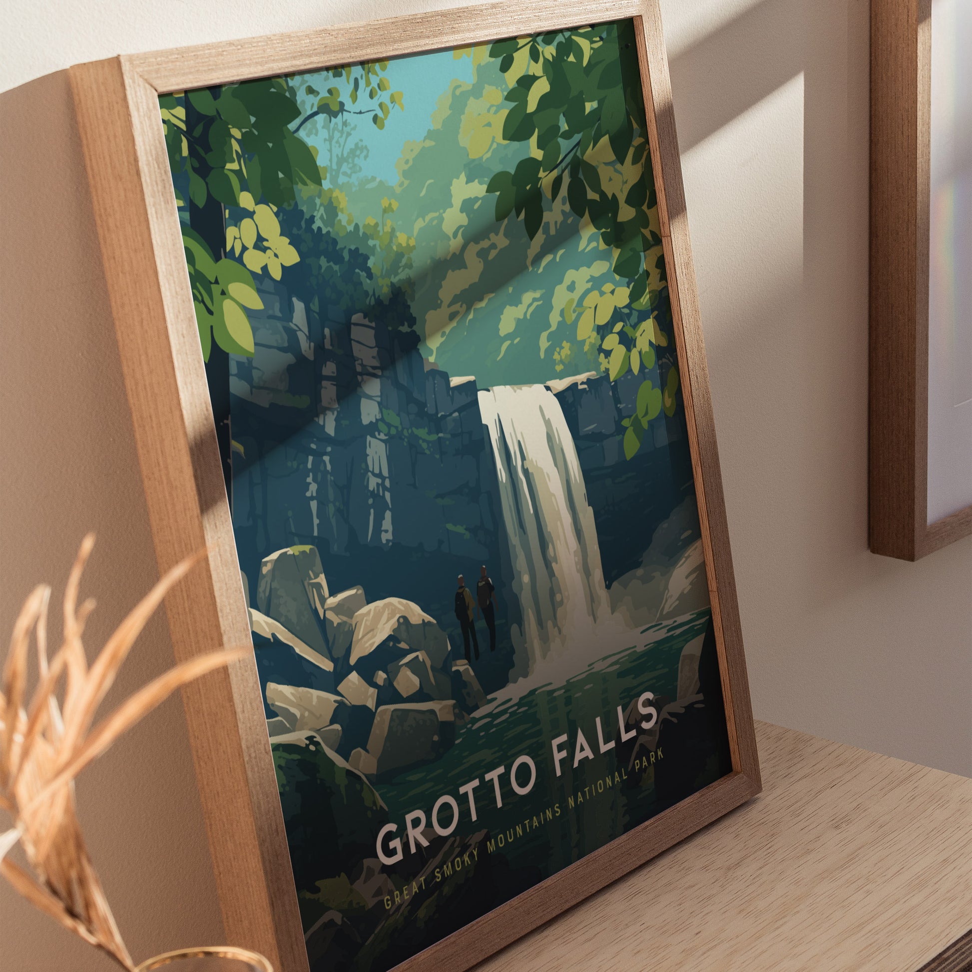 A framed poster of Grotto Falls features a stylized illustration of a waterfall cascading over rocks, surrounded by lush green foliage. Two figures stand near the base, adding a sense of scale and adventure.