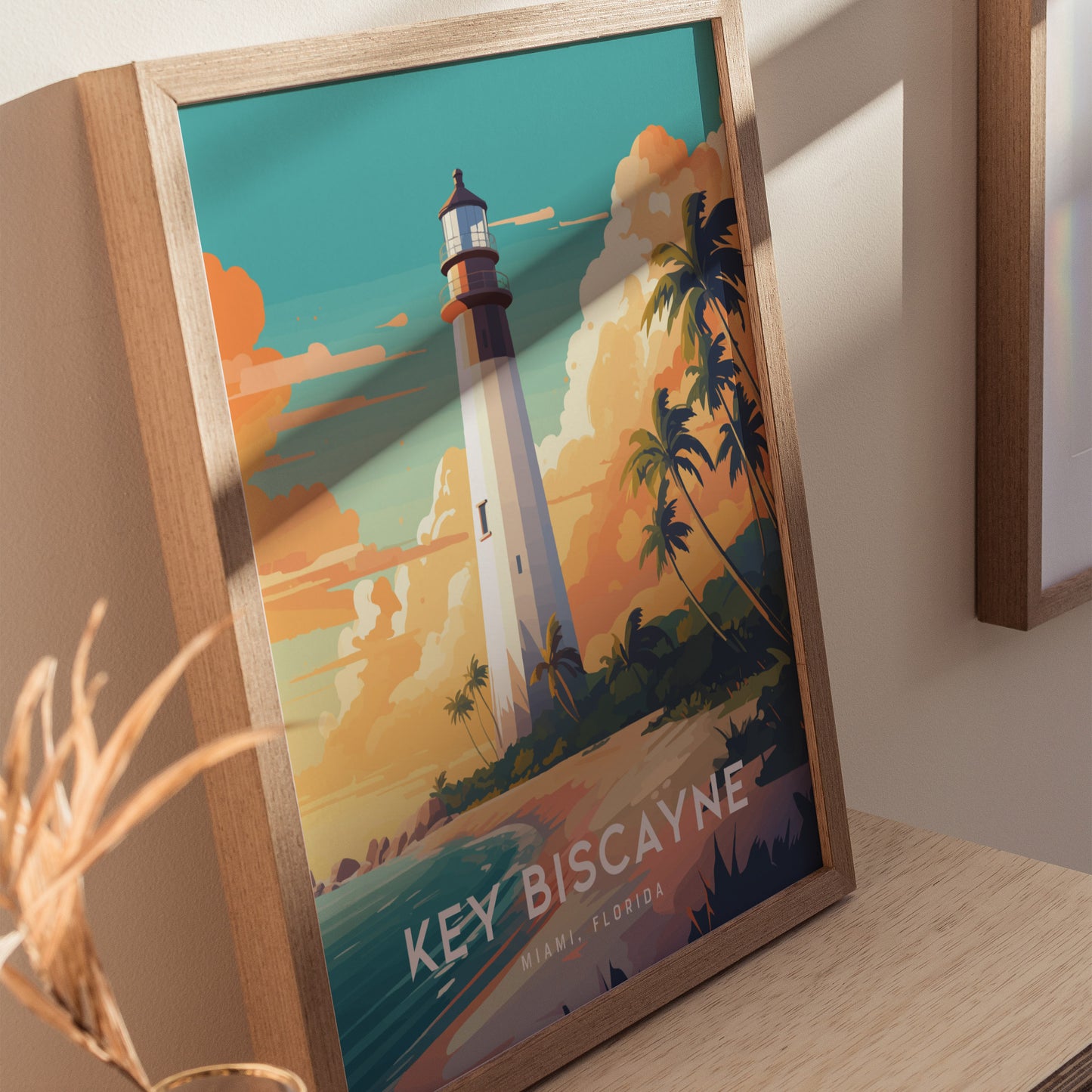 A framed poster of the Key Biscayne Lighthouse features a vibrant sunset sky, palm trees, and ocean waves, creating a tropical ambiance. The text reads Key Biscayne, Miami, Florida.
