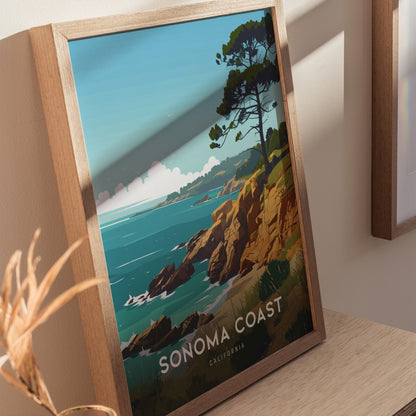 Framed poster of Sonoma Coast, California, featuring rocky shores and a single tree overlooking the ocean under a clear blue sky, displayed on a wooden surface.