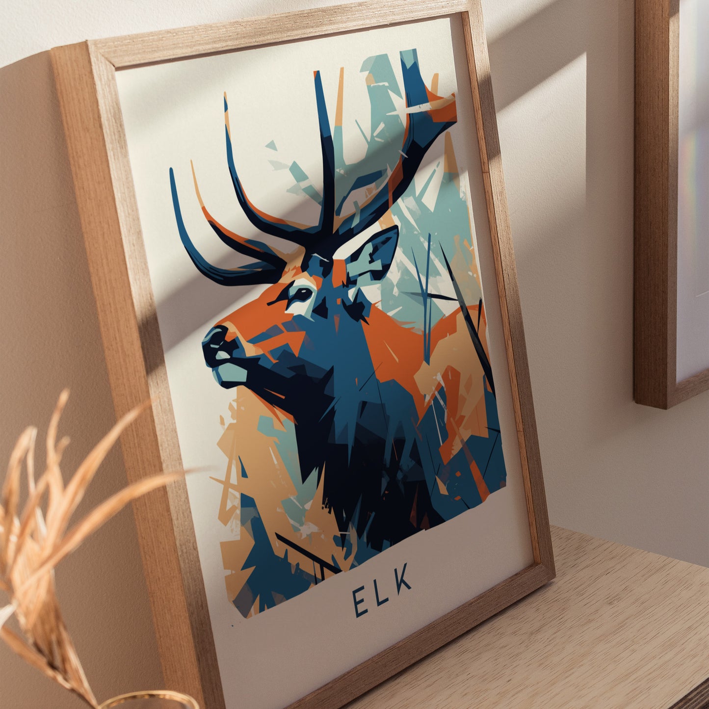 A close-up of a framed geometric wall art print featuring a stylized elk with vibrant blue and orange colors.