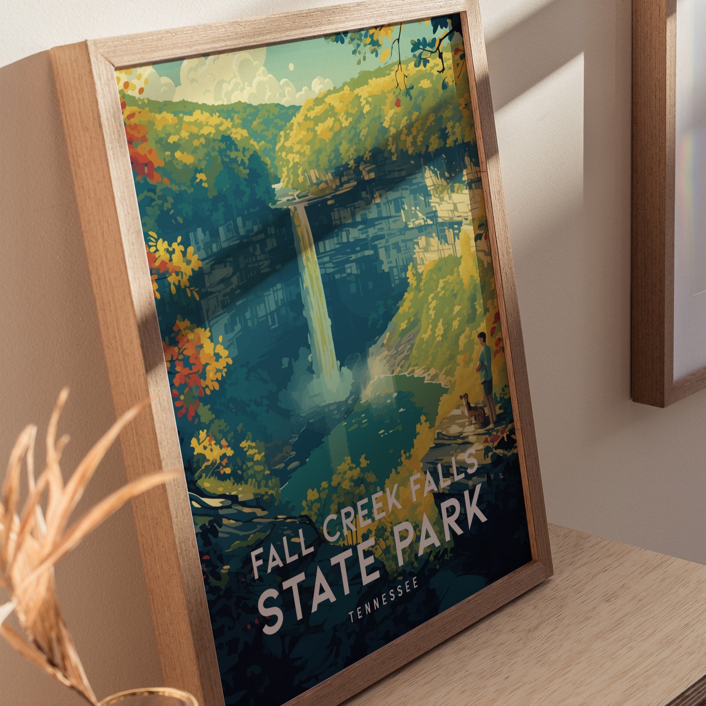 A framed poster depicts Fall Creek Falls with vibrant autumn foliage, a waterfall cascading into a gorge, and a hiker with a dog on a ledge.