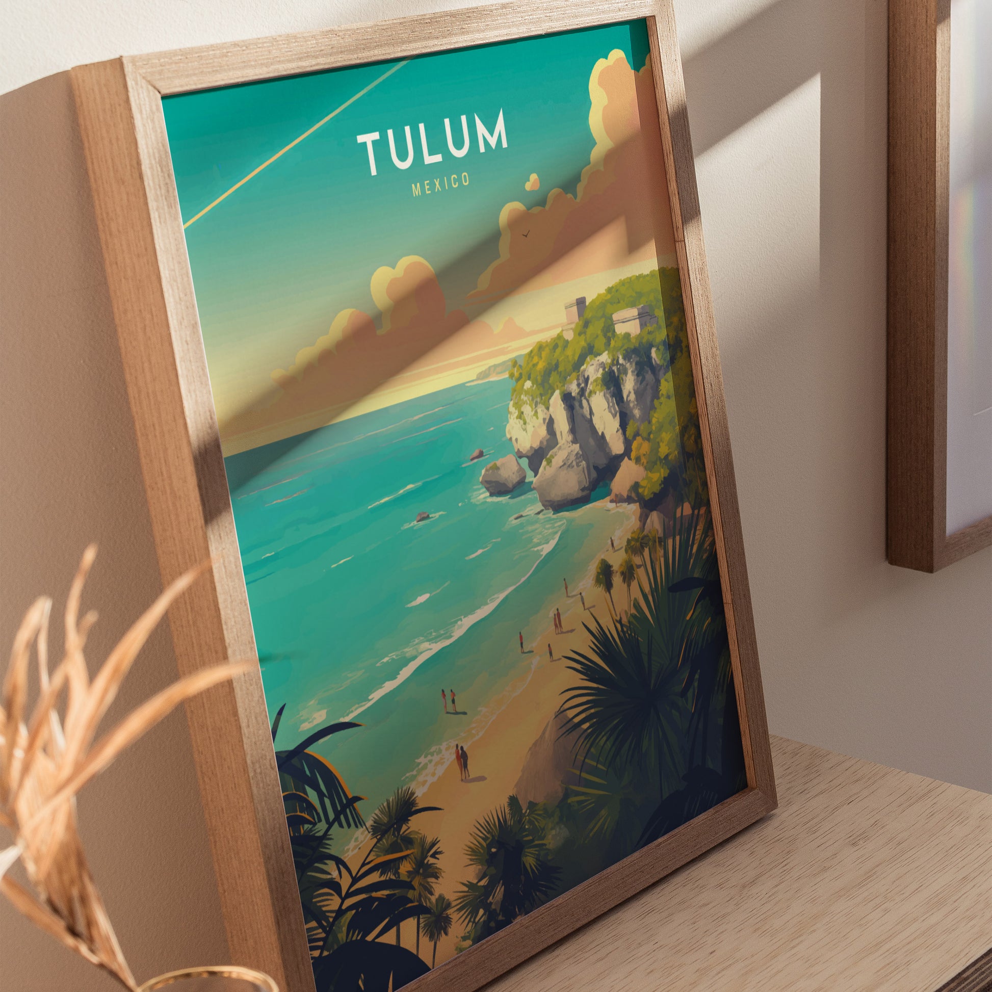 Framed artwork depicting Tulum, Mexico, shows vibrant turquoise waters, limestone cliffs, and Mayan ruins. The poster captures a scenic beach with people and lush vegetation under a clear sky.