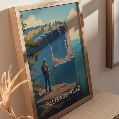 Framed artwork featuring a hiker overlooking Palisade Heads cliffs with a vibrant landscape, displayed on a wooden surface. The poster highlights Minnesotas scenic beauty.