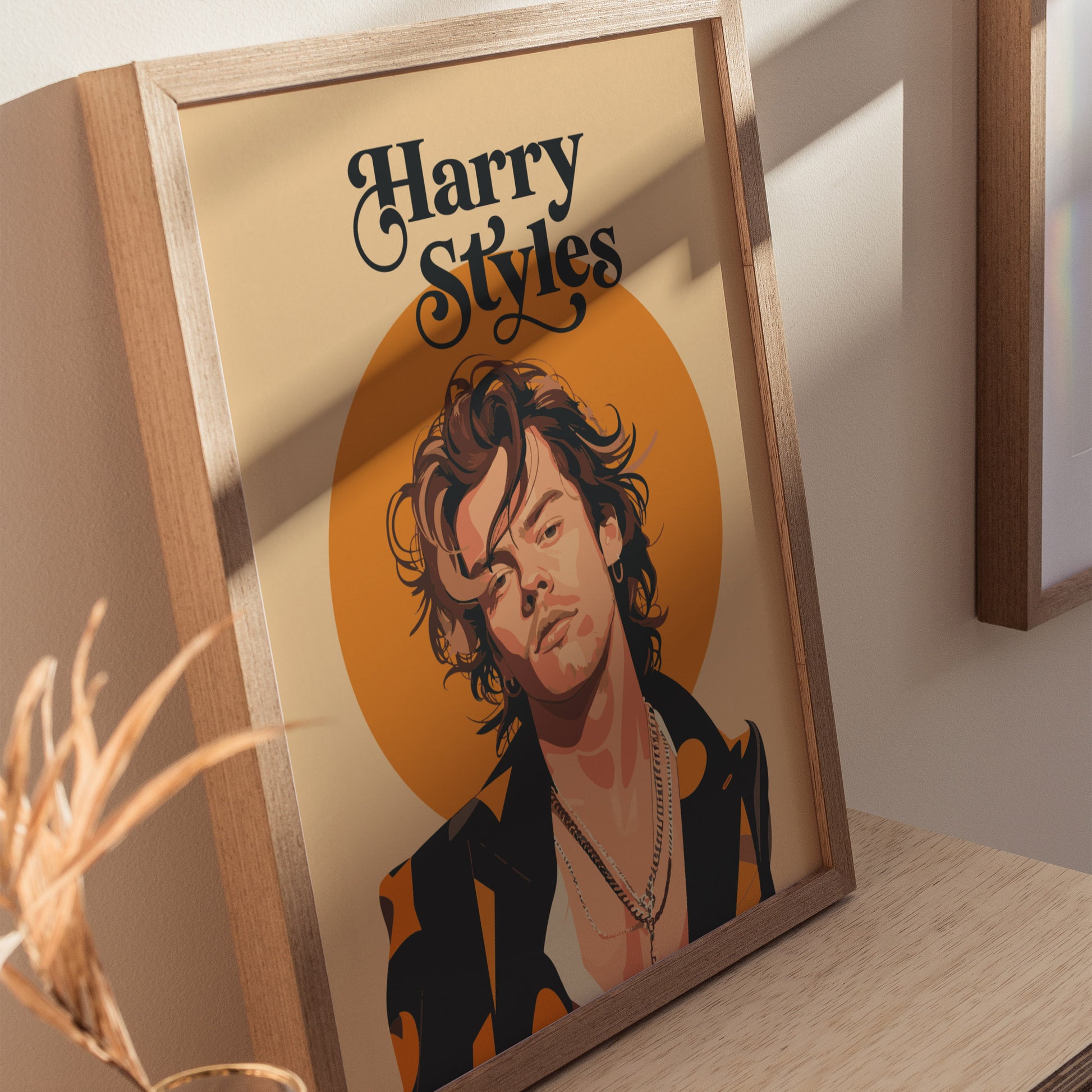 A framed illustration poster depicts a stylized portrait of a person with layered necklaces and a chic jacket, set against a warm orange circle. The text reads Harry Styles.