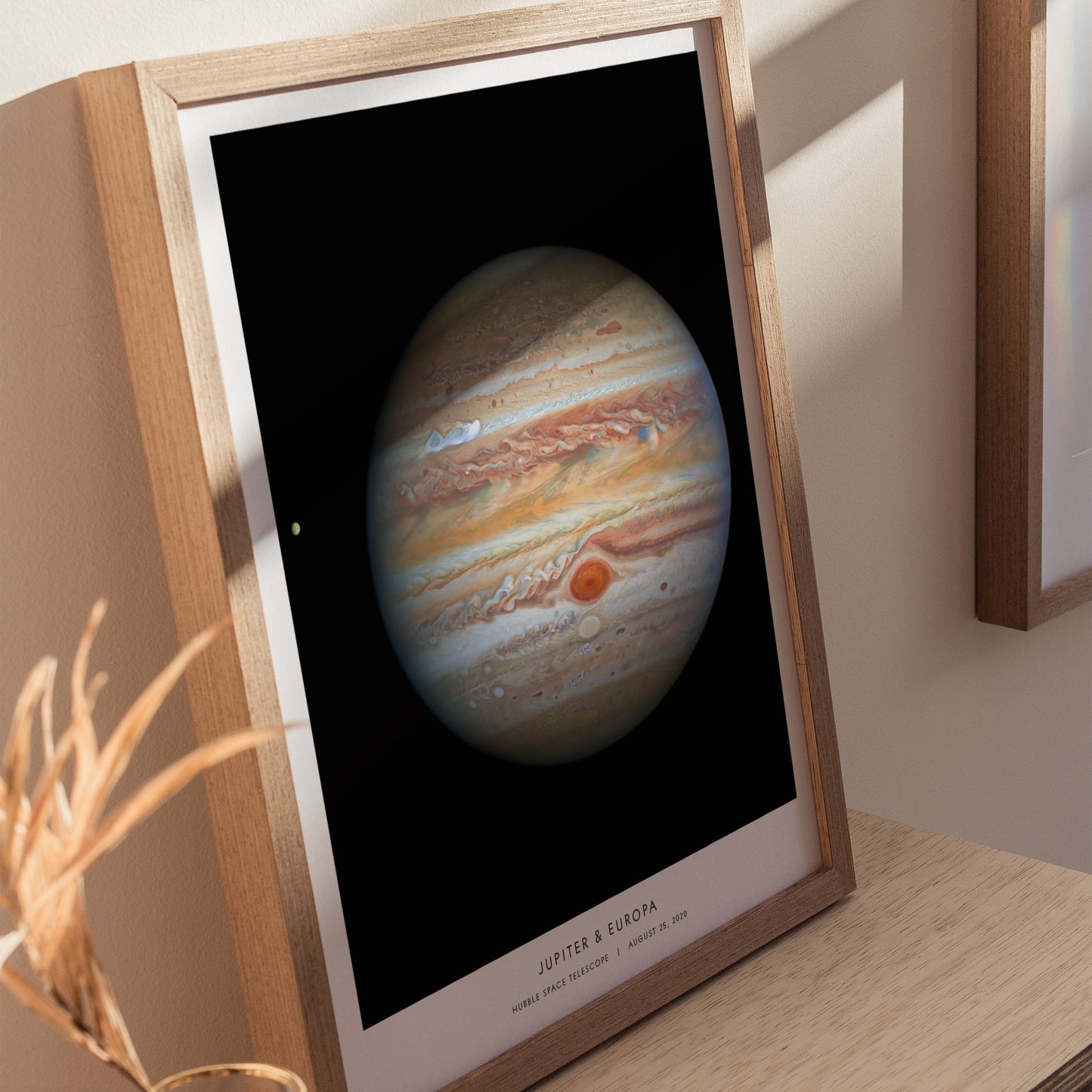 Framed poster of Jupiter on a wooden surface