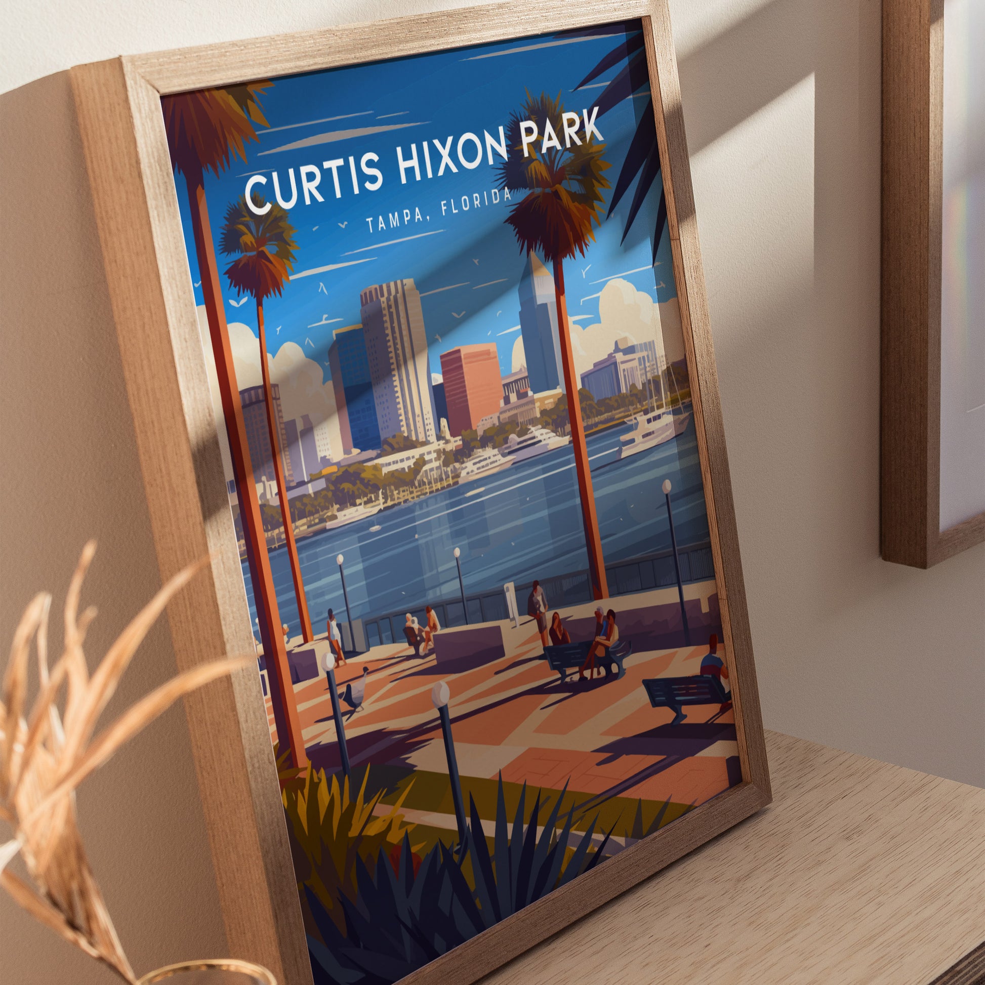Framed artwork of Curtis Hixon Park in Tampa, Florida, featuring people walking along a riverside promenade with palm trees, city skyline, and boats on the water under a blue sky.