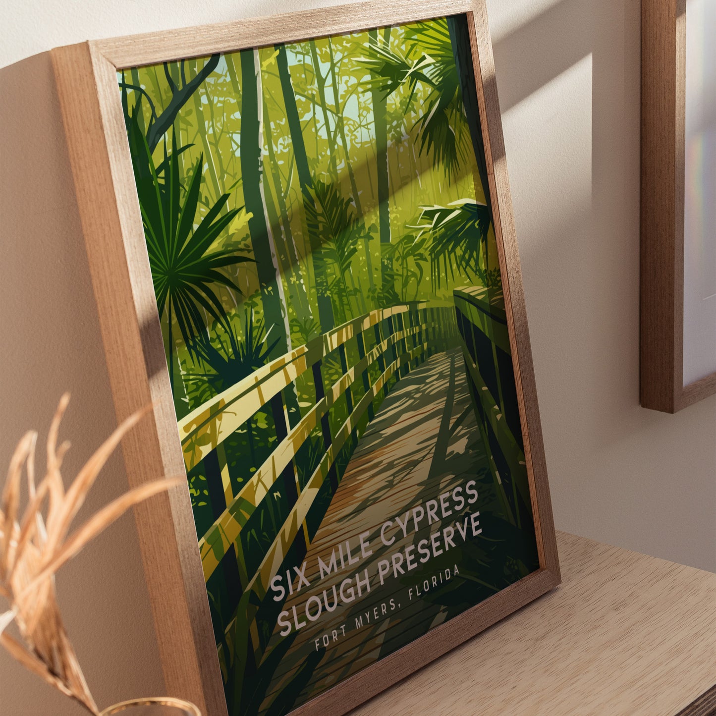 Framed poster featuring a wooden boardwalk winding through lush green foliage and tall trees, titled Six Mile Cypress Slough Preserve in Fort Myers, Florida.