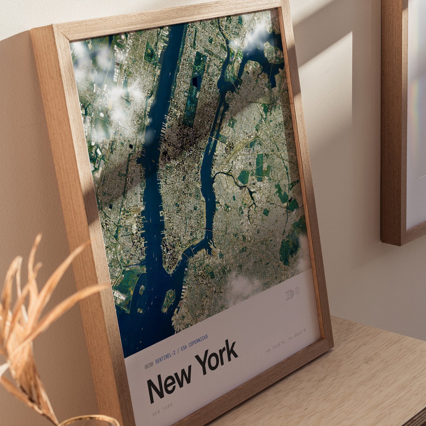 Aerial view of New York City displayed in a wooden-framed poster. The image captures the intricate details of the urban landscape, including the grid pattern of streets, waterways, and parks, under a partly cloudy sky.