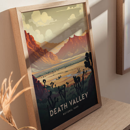 Framed art print of Death Valley National Park features a colorful landscape with rugged mountains, desert vegetation, and a dramatic sky. The wooden frame rests on a light wooden surface.