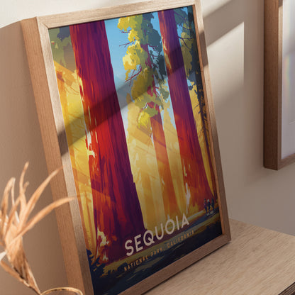 Framed poster featuring vibrant artwork of towering sequoia trees with sunlight filtering through, labeled Sequoia National Park, California, resting on a wooden surface.