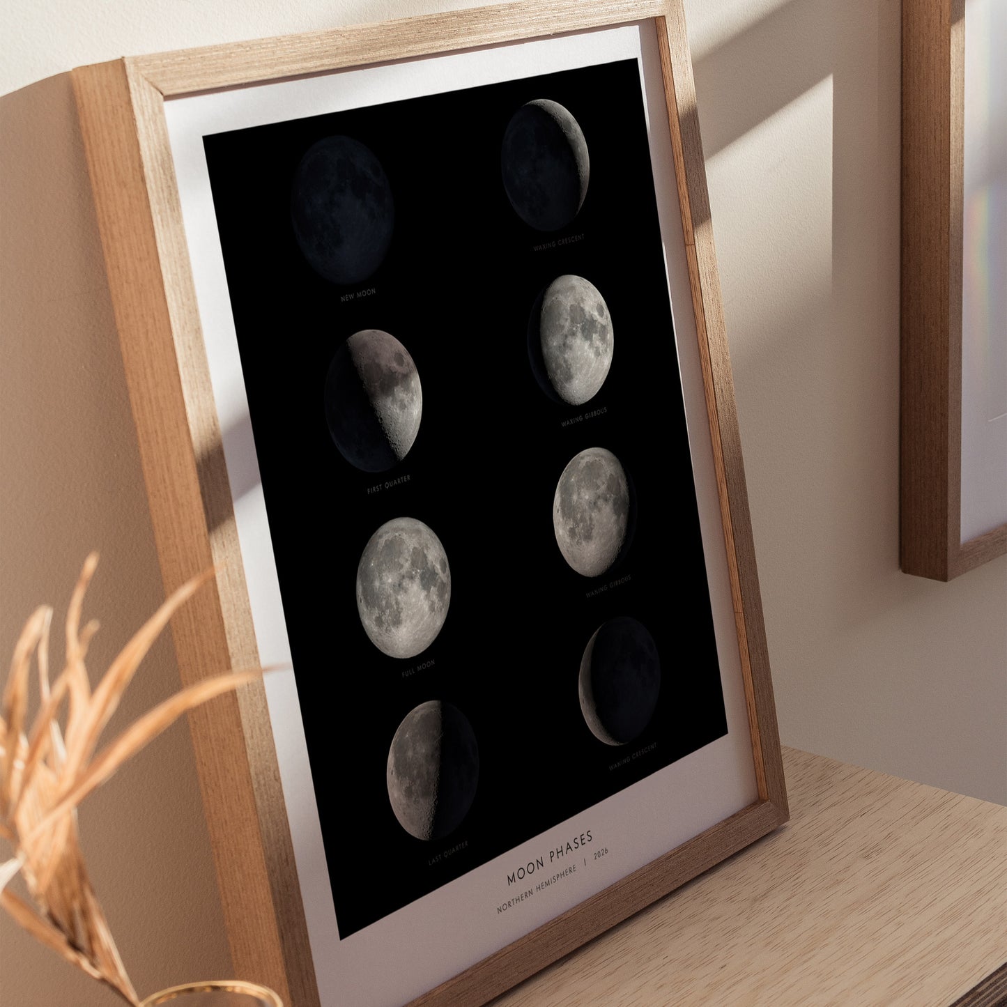 A framed educational poster of the moon phases, featuring all eight stages of the lunar cycle displayed in stunning detail. The images are arranged in two columns against a black background, with labeled phases at the bottom.