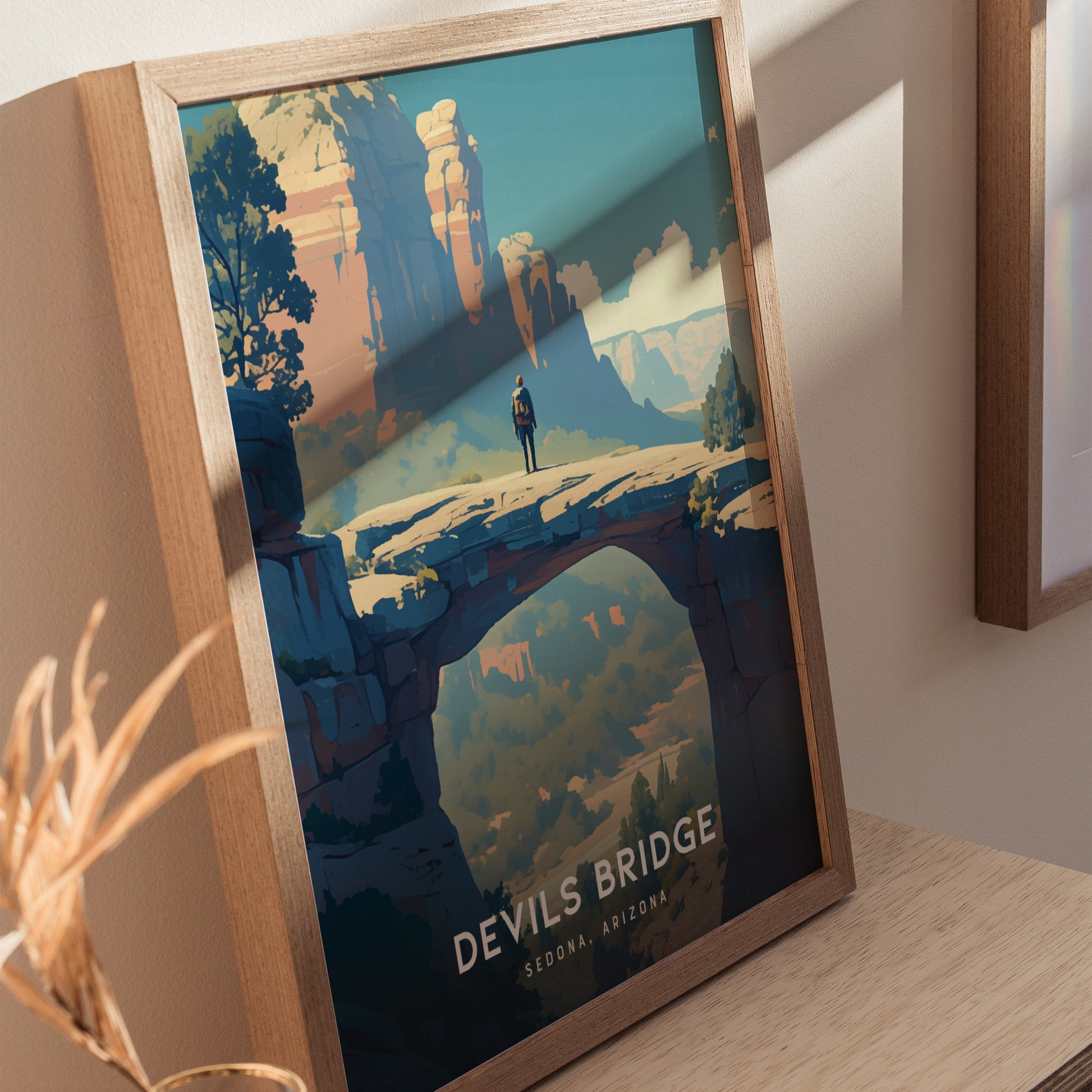 A framed poster of Devils Bridge in Sedona, Arizona, featuring a lone hiker on a natural sandstone arch with vibrant desert cliffs in the background.