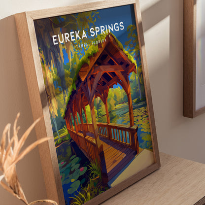 Framed artwork of Eureka Springs in Tampa, Florida, showcasing a wooden bridge over a lily-filled stream, surrounded by lush greenery and Spanish moss.