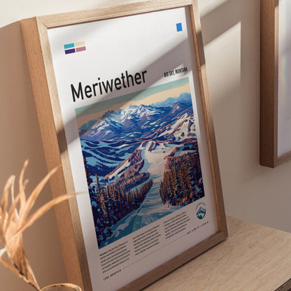 Framed poster of the Meriwether ski run at Big Sky, Montana, featuring vibrant artwork of snowy mountains and forested slopes. Displayed on a light wooden surface.