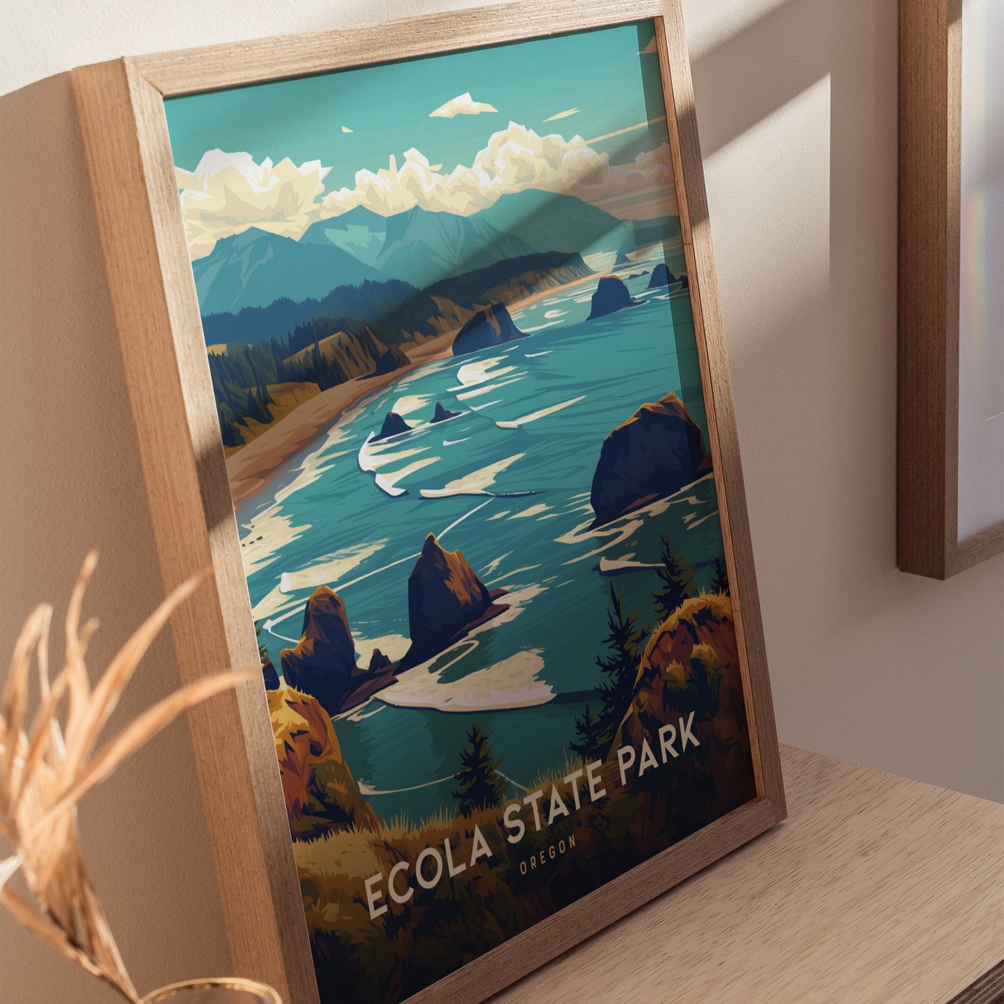 Framed illustration of Ecola State Park, showcasing vibrant green headlands and rugged cliffs overlooking the blue Pacific Ocean. The poster is displayed on a wooden surface.