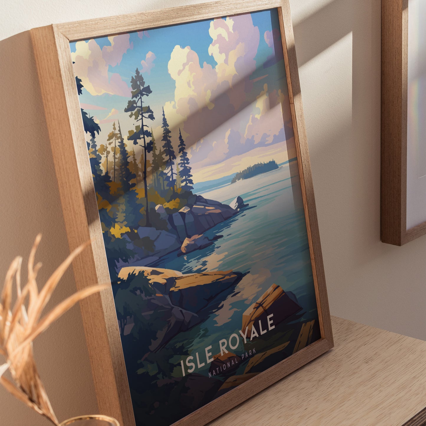 Framed poster of Isle Royale National Park showcasing a scenic view of rocky shorelines, pine trees, and a serene lake under a cloudy sky.