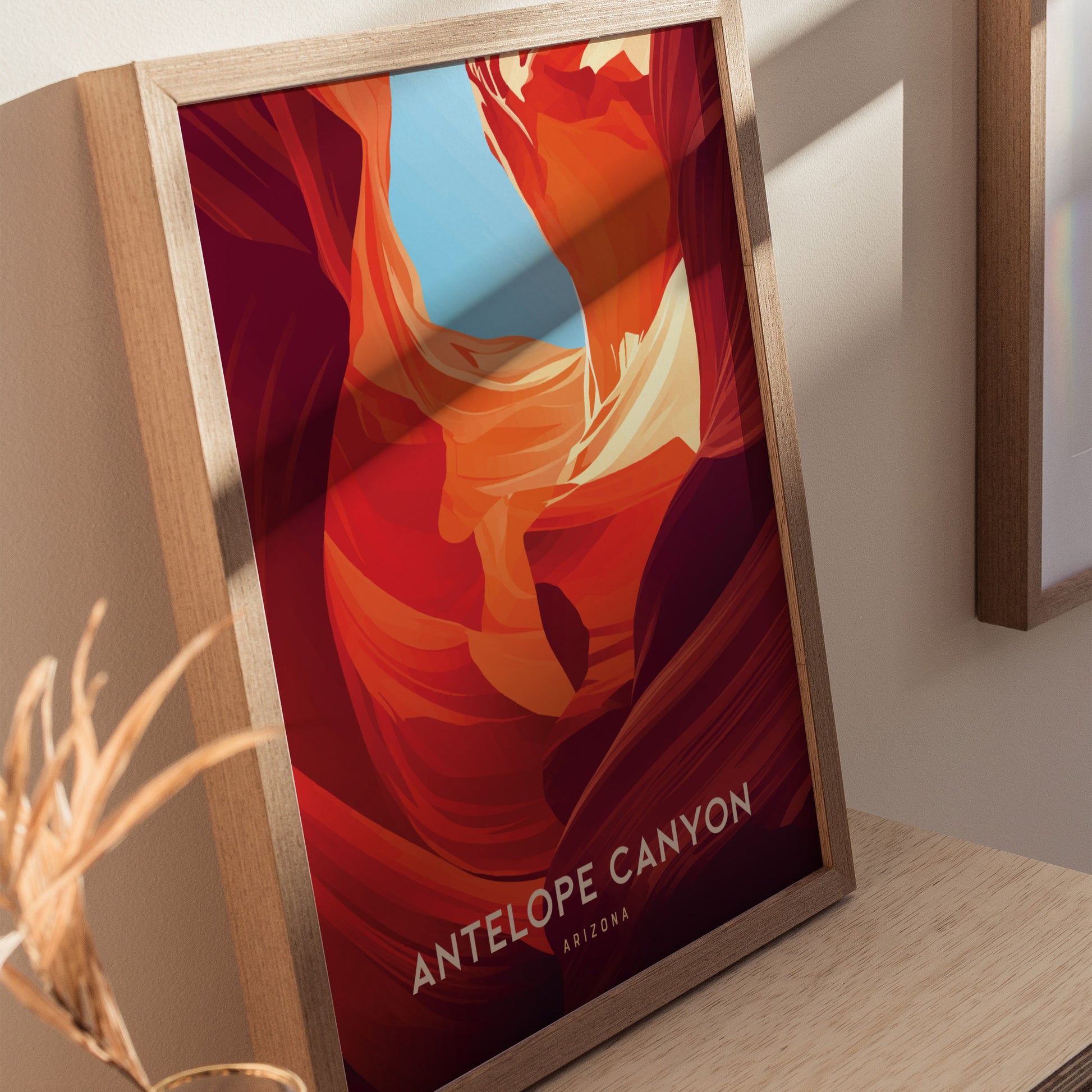 Framed Antelope Canyon poster featuring vibrant red and orange sandstone formations with a hint of blue sky, placed on a wooden surface, casting a soft shadow.