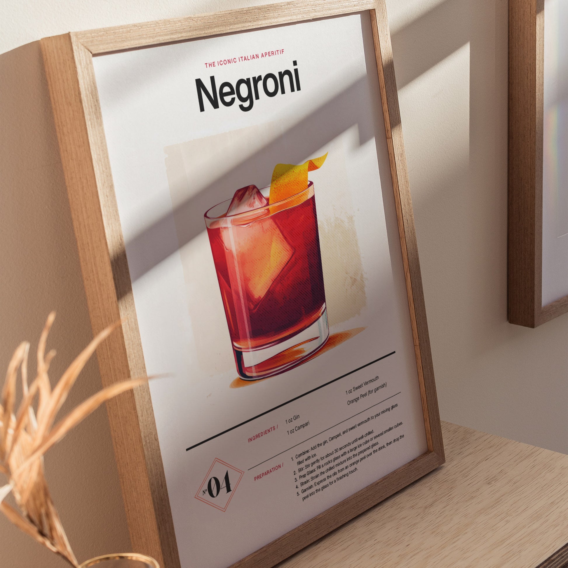 Framed Negroni cocktail poster with a detailed illustration of the drink in a glass, garnished with an orange peel. Sunlight casts shadows on the wooden frame and surface.